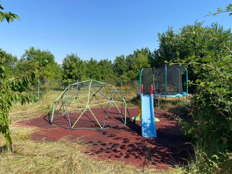 Záhrada rodinného domu v Borši na Hlavnej ulici s hojdačkou a trampolínou.