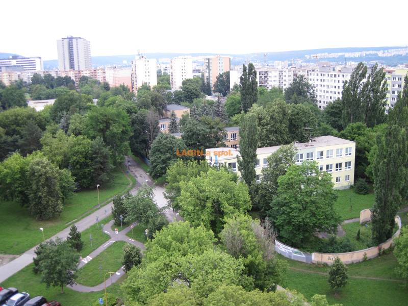 Pohľad na zeleň medzi bytovkami a školou na Poľovníckej ulici, Košice - mestská časť Západ.